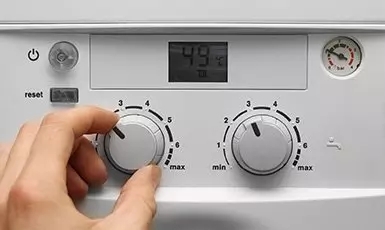 adjusting dials on a boiler